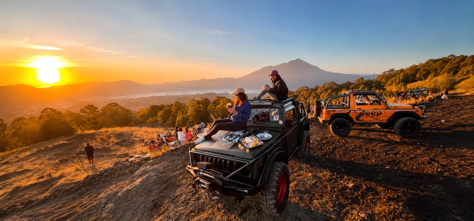 Mount Batur sunrise jeep tour in Bali with golden morning light over volcanic terrain
